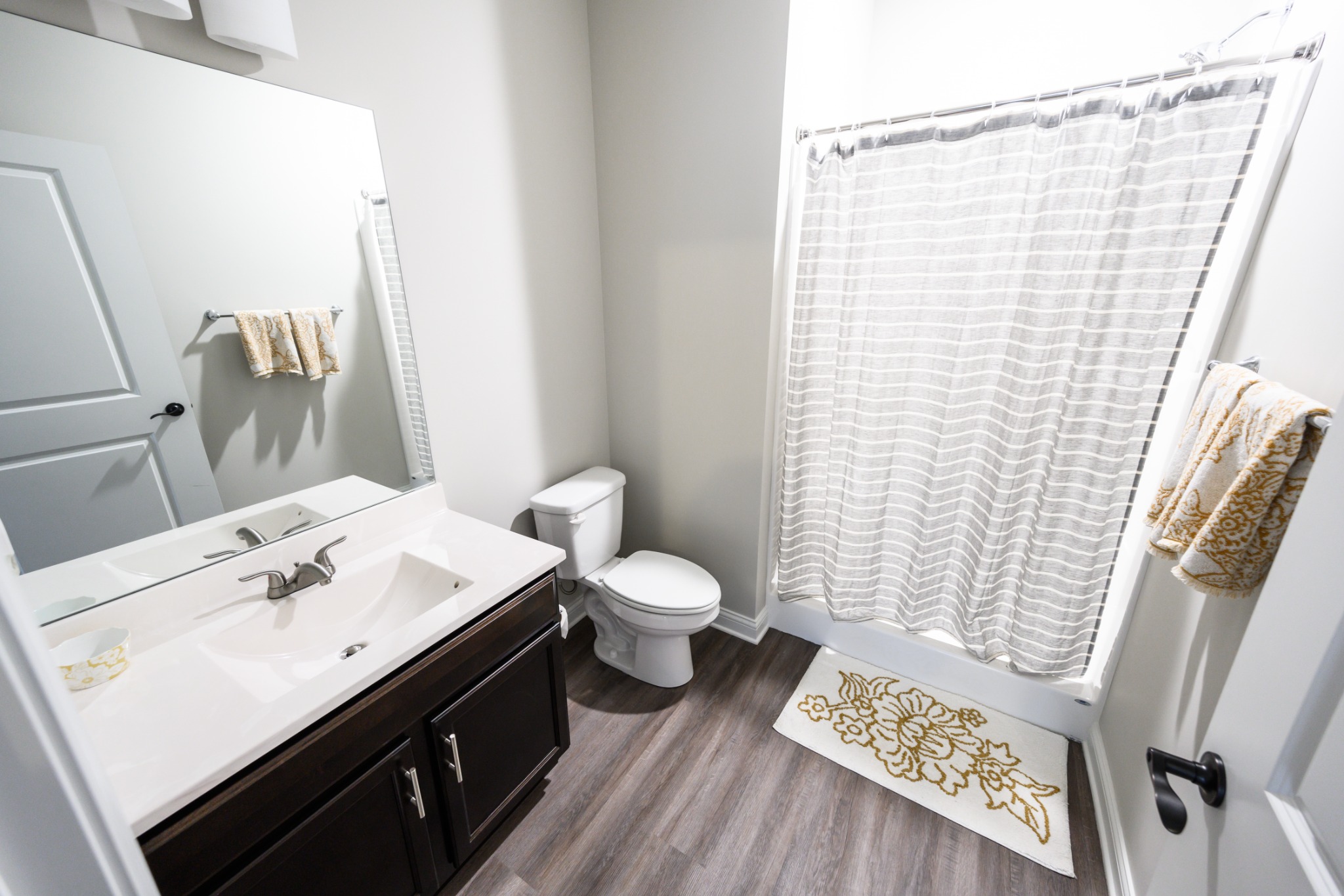 Full bathroom with large mirror and dark wood vanity
