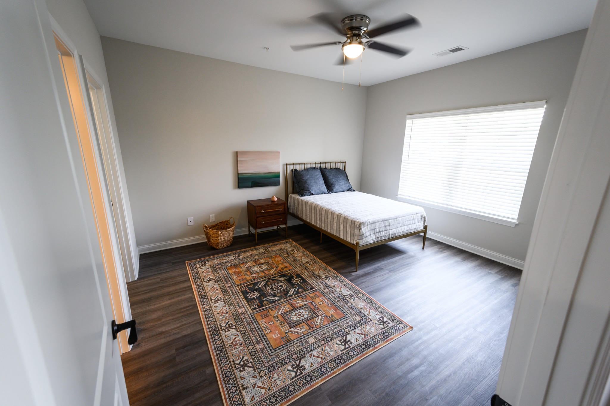Spacious furnished bedroom with ceiling fan